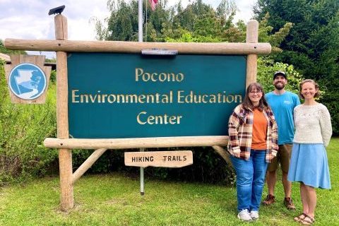 Kirsten, Derek, and Amanda standing next to the Pocono Environmental Education Center sign