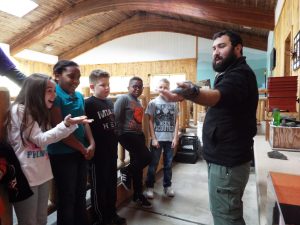 A PEEC instructor showing a group of students a black rat snake