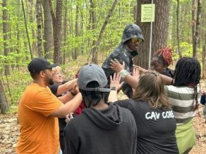 A group of students and chaperones on a low ropes course